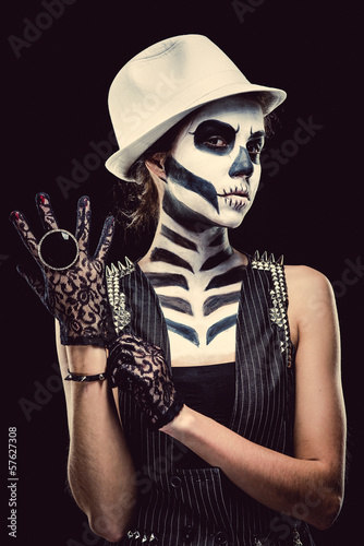 Photo: Woman with skeleton face art over black background Woman with skeleton face art over black background