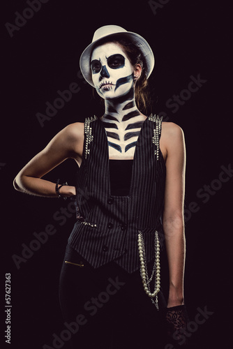 Photo: Woman with skeleton face art over black background Woman with skeleton face art over black background