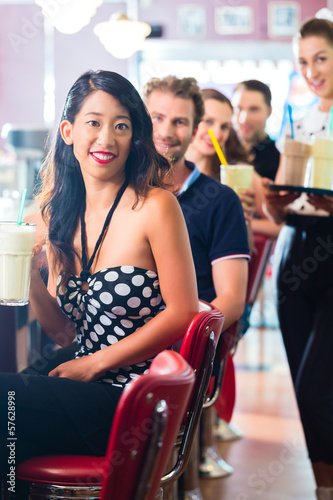 Photo: People in American diner or restaurant with milk shakes People in American diner or restaurant with milk shakes