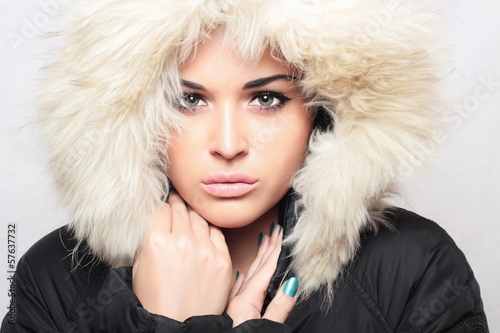 Photo: Fashion portrait of young beautiful woman with fur.fur hood Fashion portrait of young beautiful woman with fur.fur hood