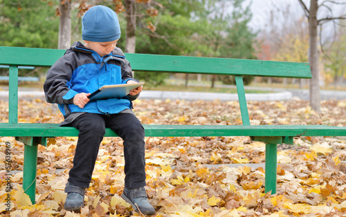 Photo: Little boy reading a tablet computer Little boy reading a tablet computer
