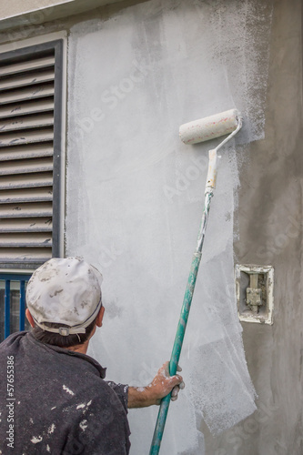 Photo: builder worker painting a wall 2 builder worker painting a wall 2