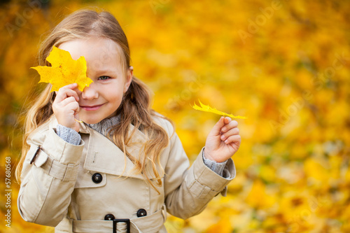 Photo: Little girl outdoors at autumn day Little girl outdoors at autumn day