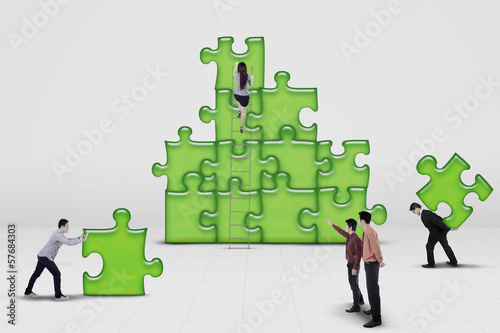 Photo: Business team work building a puzzle Business team work building a puzzle