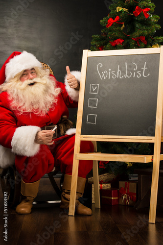 Photo: Santa Claus sitting near chalkboard Santa Claus sitting near chalkboard