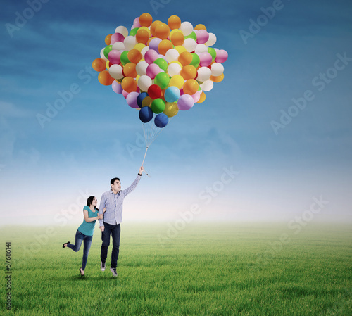 Photo: Young couple with colorful balloons Young couple with colorful balloons