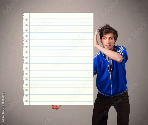 Photo: Young man holding white paper copy space with diagonal lines Young man holding white paper copy space with diagonal lines