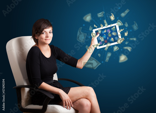 Photo: young woman holding tablet with money young woman holding tablet with money