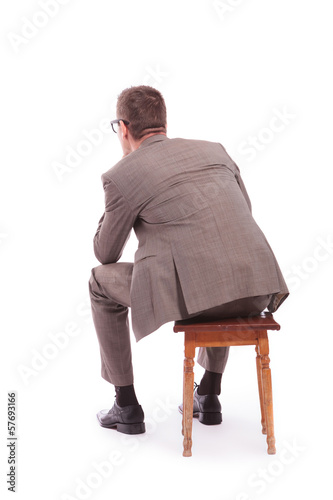 Photo: back of a young business man sitting on a chair back of a young business man sitting on a chair