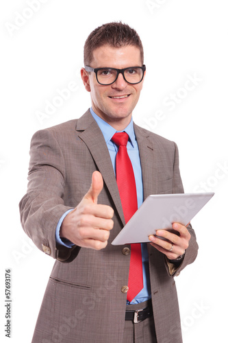 Photo: young business man holds tablet and shows thumb up young business man holds tablet and shows thumb up