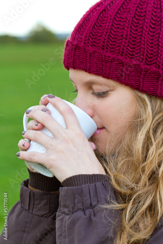 Photo: Junge Frau mit einem Heißgetränk in der Natur Junge Frau mit einem Heißgetränk in der Natur