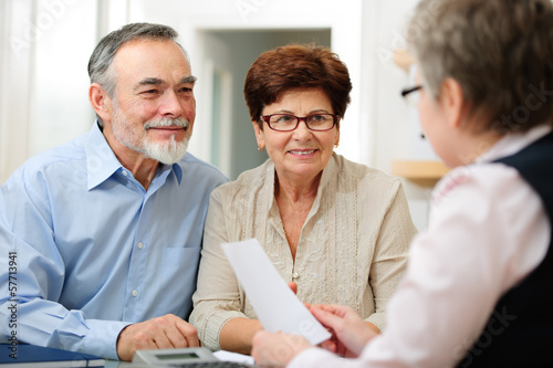 Photo: Senior couple discussing financial plan with consultant Senior couple discussing financial plan with consultant