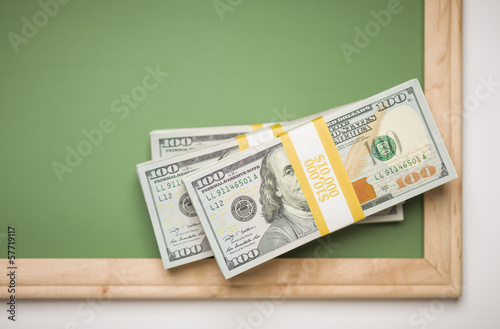 Photo: Newly Designed One Hundred Dollar Bills Stacked on Chalk Board Newly Designed One Hundred Dollar Bills Stacked on Chalk Board