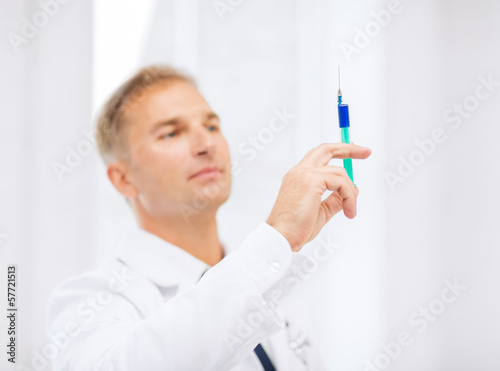 Photo: male doctor holding syringe with injection male doctor holding syringe with injection