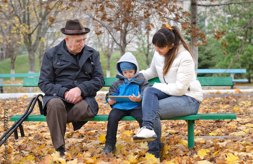 Photo: Young boy with his mother and grandfather Young boy with his mother and grandfather