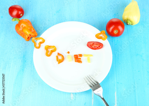 Photo: Word diet lined vegetables on plate on wooden table close-up Word diet lined vegetables on plate on wooden table close-up