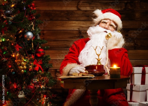Photo: Santa Claus in wooden home interior Santa Claus in wooden home interior
