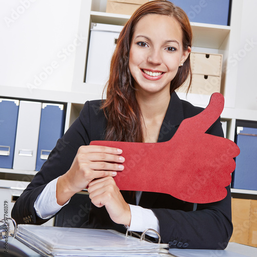 Photo: Frau im Büro hält roten Daumen hoch Frau im Büro hält roten Daumen hoch