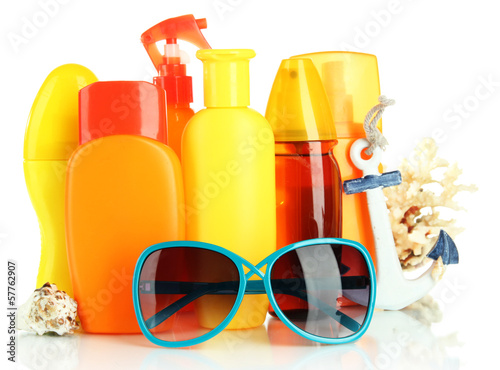 Photo: Bottles with suntan cream and sunglasses isolated on white Bottles with suntan cream and sunglasses isolated on white