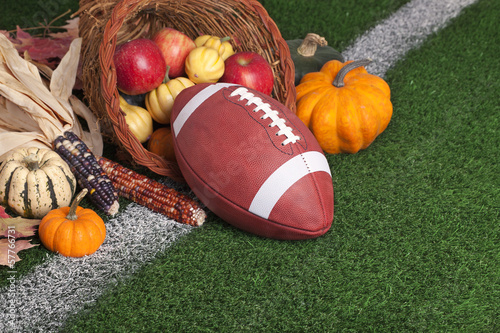 Photo: College style Football with a cornucopia on grass field College style Football with a cornucopia on grass field