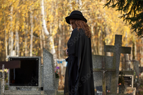 Photo: Widow looking at the gravestone Widow looking at the gravestone