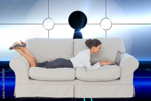 Photo: Composite image of business woman lying on couch Composite image of business woman lying on couch