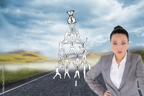 Photo: Composite image of unsmiling asian businesswoman pointing Composite image of unsmiling asian businesswoman pointing