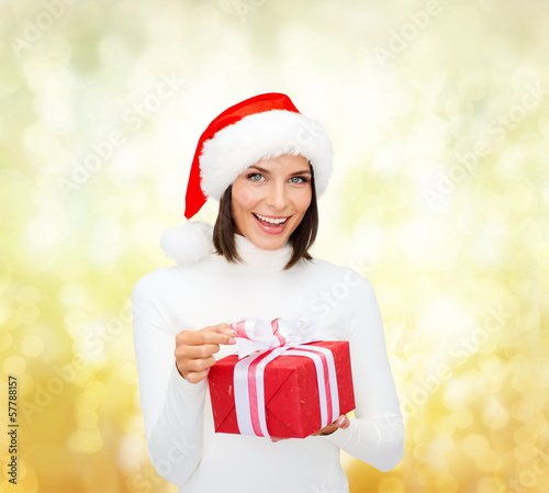 Photo: smiling woman in santa helper hat with gift box smiling woman in santa helper hat with gift box