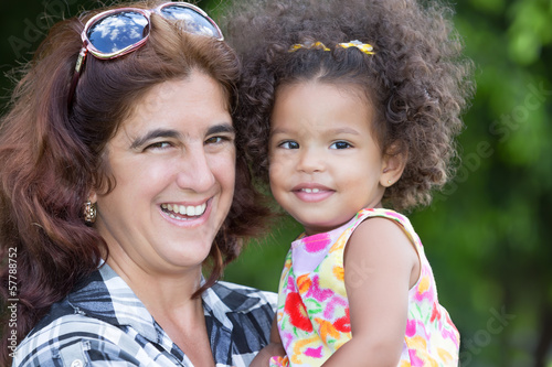 Photo: Hispanic woman carrying a small girl outdoors Hispanic woman carrying a small girl outdoors