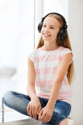Photo: little girl with headphones at home little girl with headphones at home