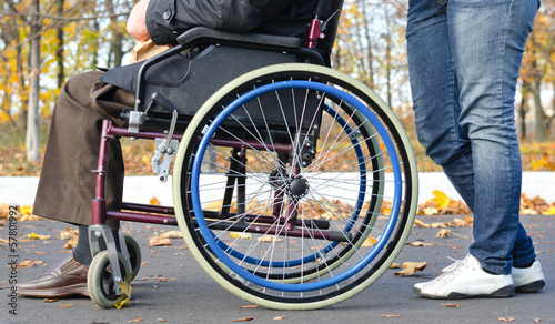 Photo: Disabled man in a wheelchair with a carer Disabled man in a wheelchair with a carer
