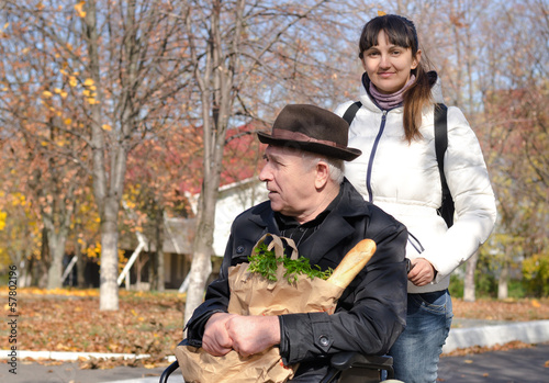 Photo: Woman taking an elderly disabled man shopping Woman taking an elderly disabled man shopping