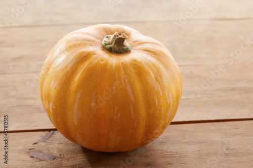 Photo: Whole raw pumpkin on wooden table Whole raw pumpkin on wooden table