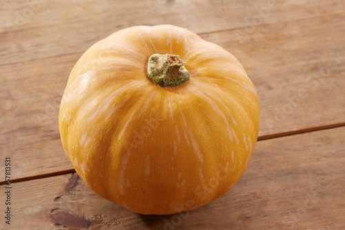 Photo: Whole raw pumpkin on wooden table Whole raw pumpkin on wooden table