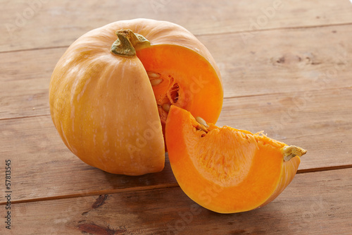 Photo: Open raw pumpkin on wooden table Open raw pumpkin on wooden table
