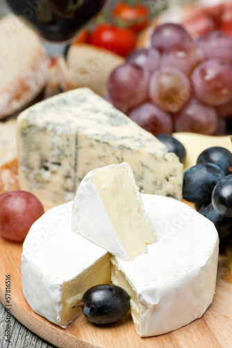 Photo: Camembert, blue cheese, grapes and walnuts on wooden board Camembert, blue cheese, grapes and walnuts on wooden board