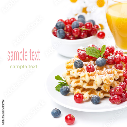 Photo: delicious breakfast with waffles, berries, juice, isolated delicious breakfast with waffles, berries, juice, isolated