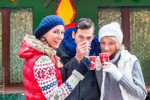 Photo: Freunde trinken Glühwein auf Weihnachtsmarkt Freunde trinken Glühwein auf Weihnachtsmarkt