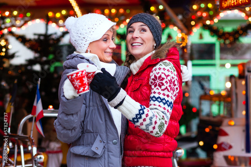 Photo: Freunde trinken Glühwein auf Weihnachtsmarkt Freunde trinken Glühwein auf Weihnachtsmarkt