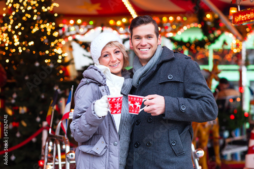 Photo: Pärchen trinkt Glühwein auf Weihnachtsmarkt im Advent Pärchen trinkt Glühwein auf Weihnachtsmarkt im Advent