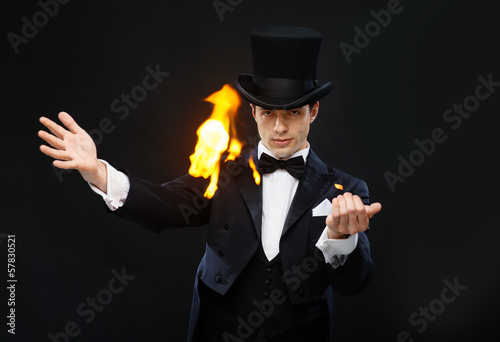 Photo: magician in top hat showing trick with fire magician in top hat showing trick with fire