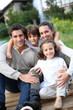 Parents with kids relaxing in front of home
