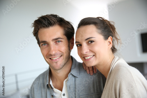 Photo: Portrait of smiling couple relaxing at home Portrait of smiling couple relaxing at home