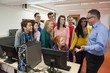 Foto: Students standing at computer chatting with their lecturer in the computer room Students standing at computer chatting with their lecturer in the computer room