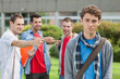 Photo: Lonely student being bullied by group of brutish classmates looking hopelessly at the camera Lonely student being bullied by group of brutish classmates looking hopelessly at the camera
