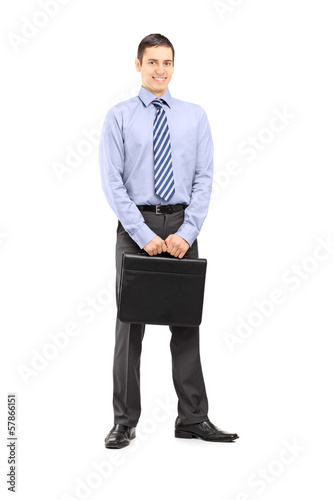 Photo: Full length portrait of a businessman holding a leather suitcase Full length portrait of a businessman holding a leather suitcase