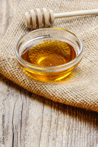 Photo: Bowl of honey on wooden table. Symbol of healthy living Bowl of honey on wooden table. Symbol of healthy living
