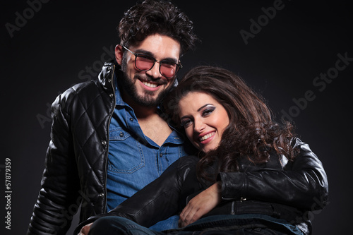 Photo: young laughing couple on a dark background young laughing couple on a dark background