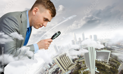 Photo: Man looking in magnifier Man looking in magnifier