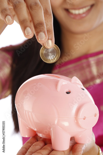 Photo: Indian woman hand inserting a ten rupee coin Indian woman hand inserting a ten rupee coin